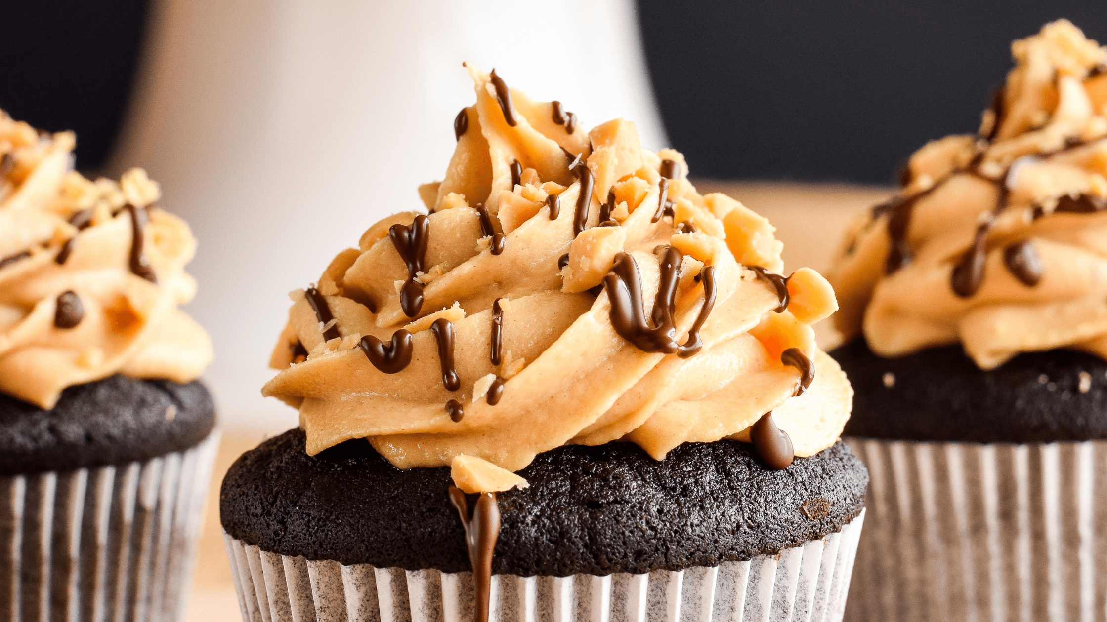 A picture of chocolate cupcakes topped with a swirl of icing.